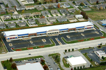 A view of an intersection with cars parked on the side.