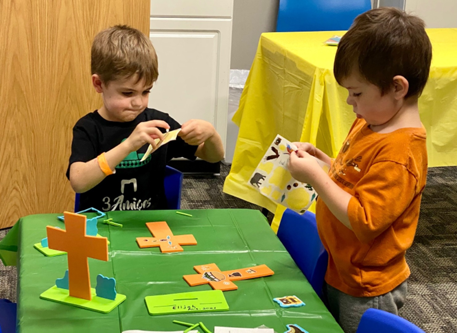 Two children are playing a game with paper.